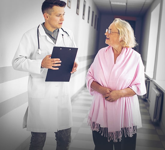 Женщина разговаривает с врачом в коридоре клиники